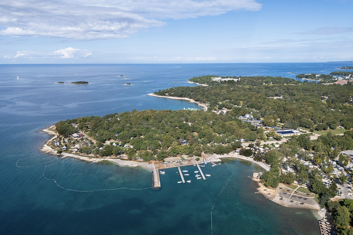 A drone photo of croatian coast from above, with blue sea and green and rocky coast.
